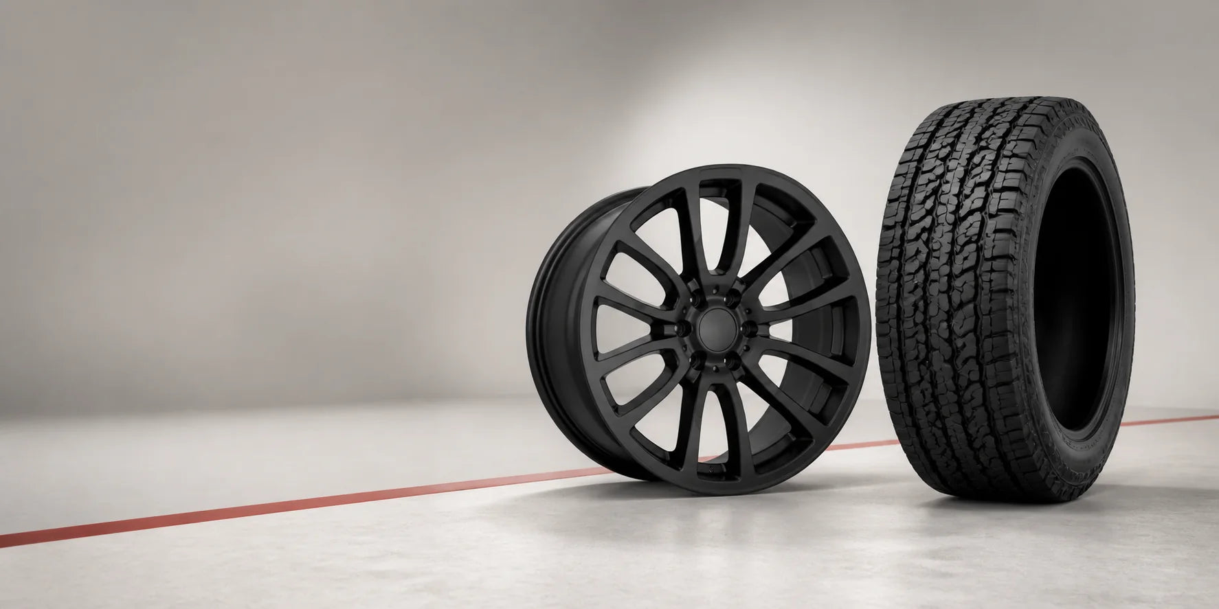Matte black alloy wheel and all-terrain tyre displayed together as a package